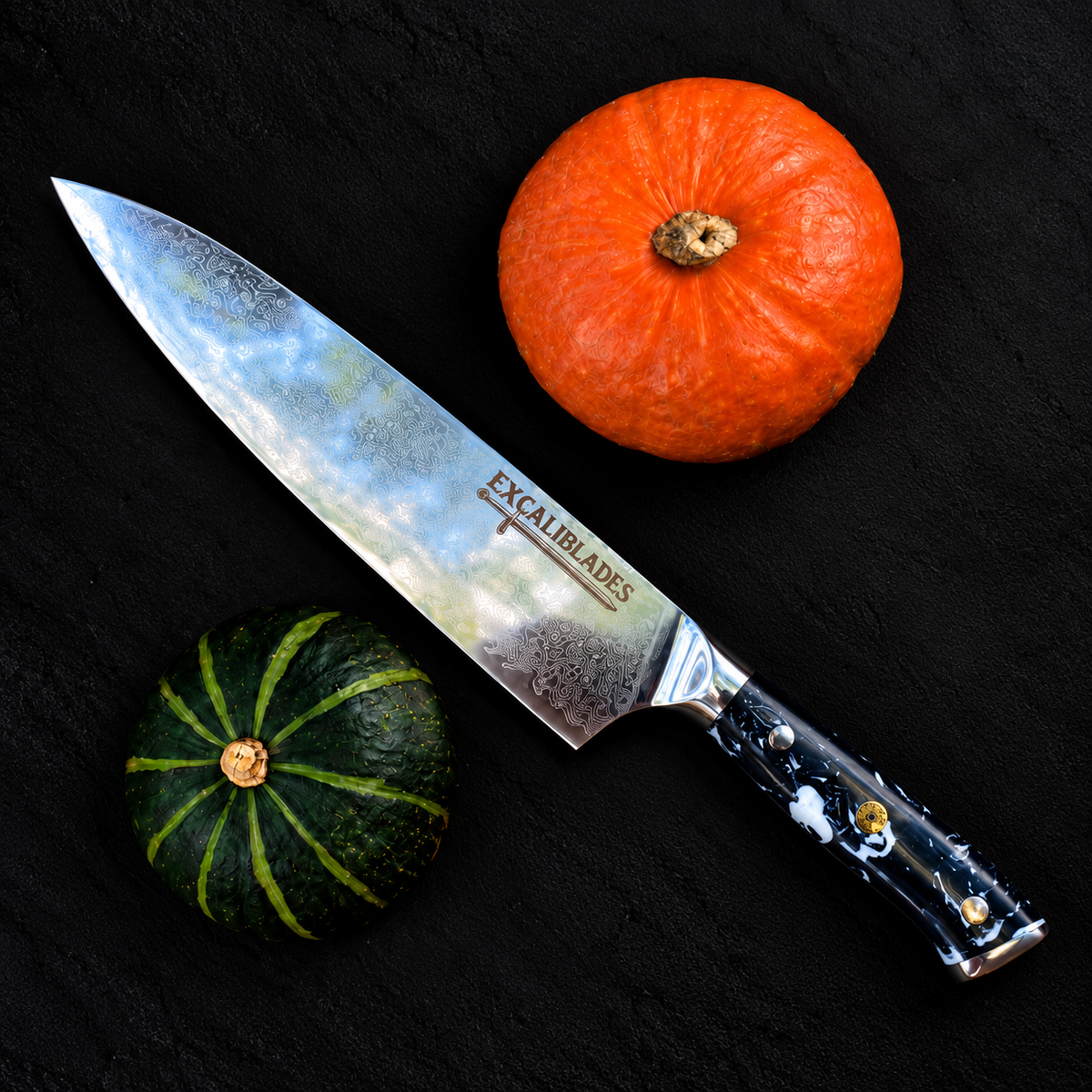Excaliblades chef knife beside orange and green pumpkins on a black background